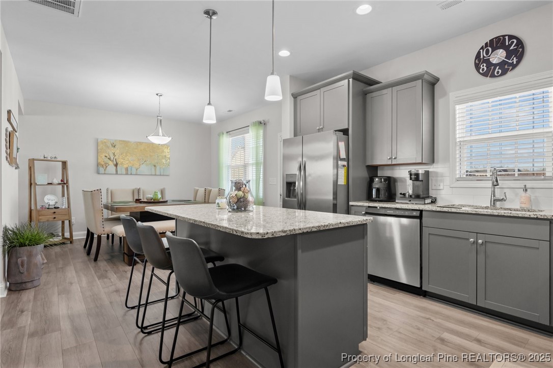 1660 Stackhouse Drive Fayetteville, NC 28314 - Photo 16 of 44 a kitchen with stainless steel appliances granite countertop a stove a sink a kitchen island with a dining table and chairs