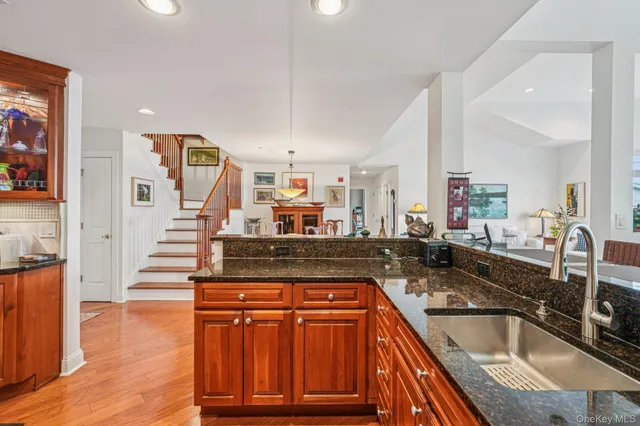 a kitchen with stainless steel appliances granite countertop a sink and a wooden floors