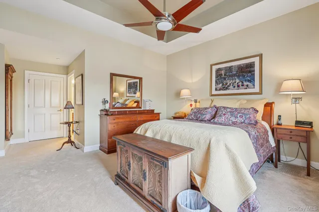 a spacious bedroom with a bed a dresser and potted plant