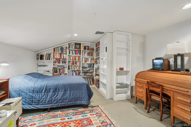 a bedroom with a bed and a book shelf