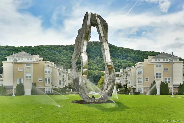 a view of a white house with a big yard and plants