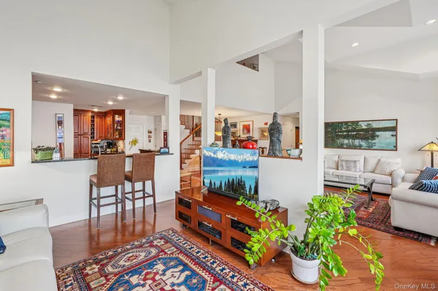 a living room filled with furniture and a dining table with wooden floor