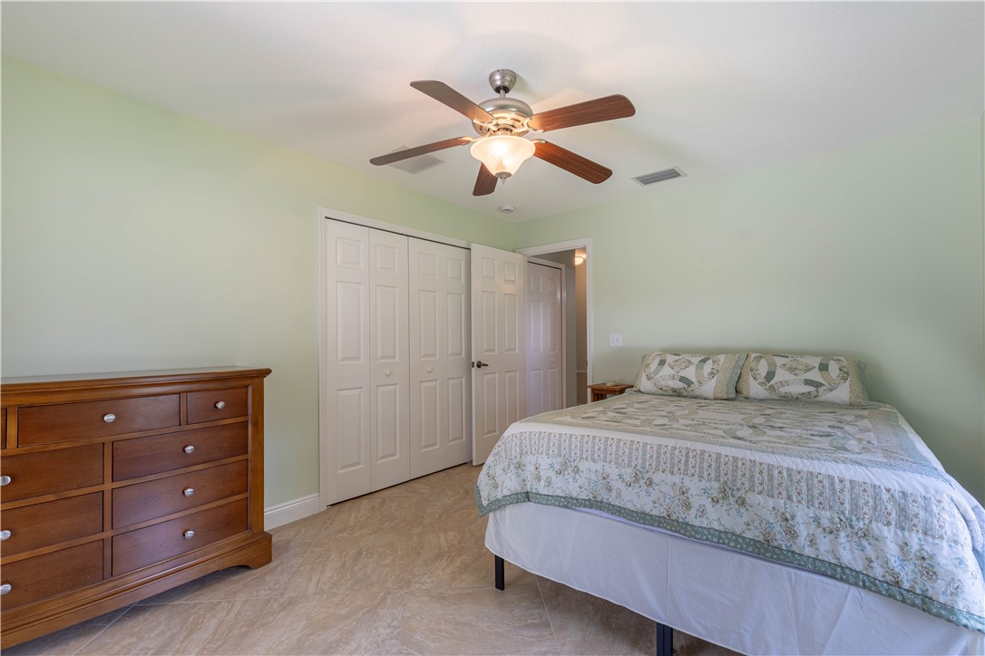 414 Ash Street Sebastian, FL 32958 - Photo 22 of 36 a bedroom with a bed and a chandelier