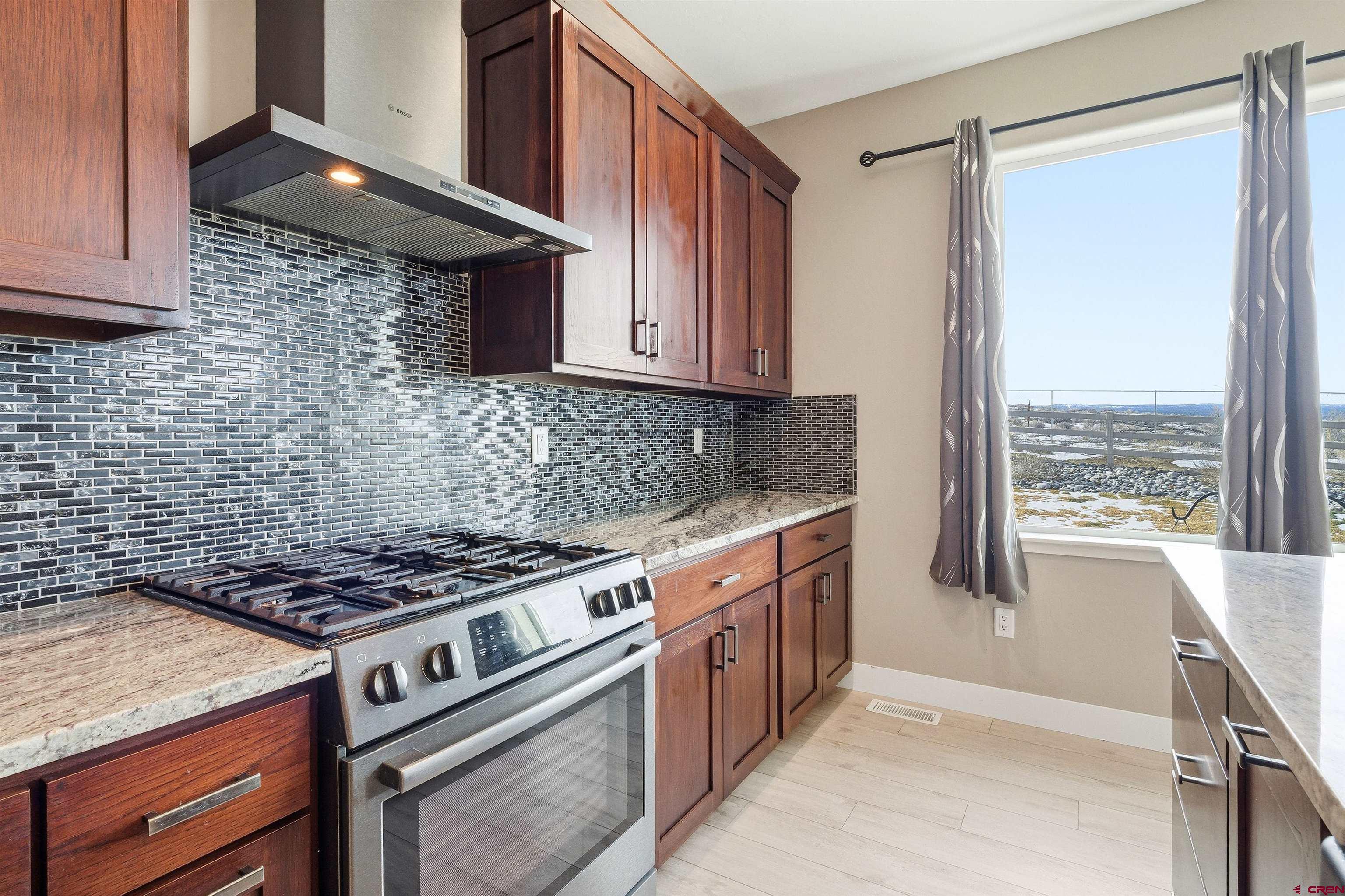 3614 Ridgeline Drive Montrose, CO 81401 - Photo 13 of 45 a kitchen with stainless steel appliances granite countertop a stove a sink and a microwave