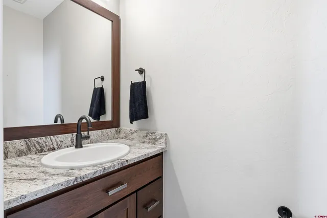 a bathroom with a granite countertop sink and a mirror