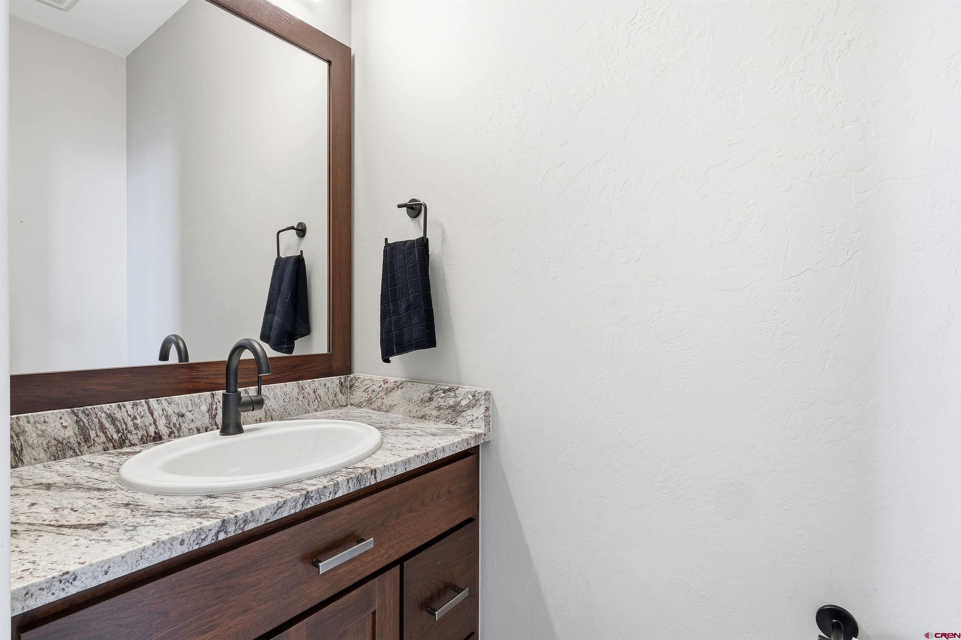 3614 Ridgeline Drive Montrose, CO 81401 - Photo 15 of 45 a bathroom with a granite countertop sink and a mirror