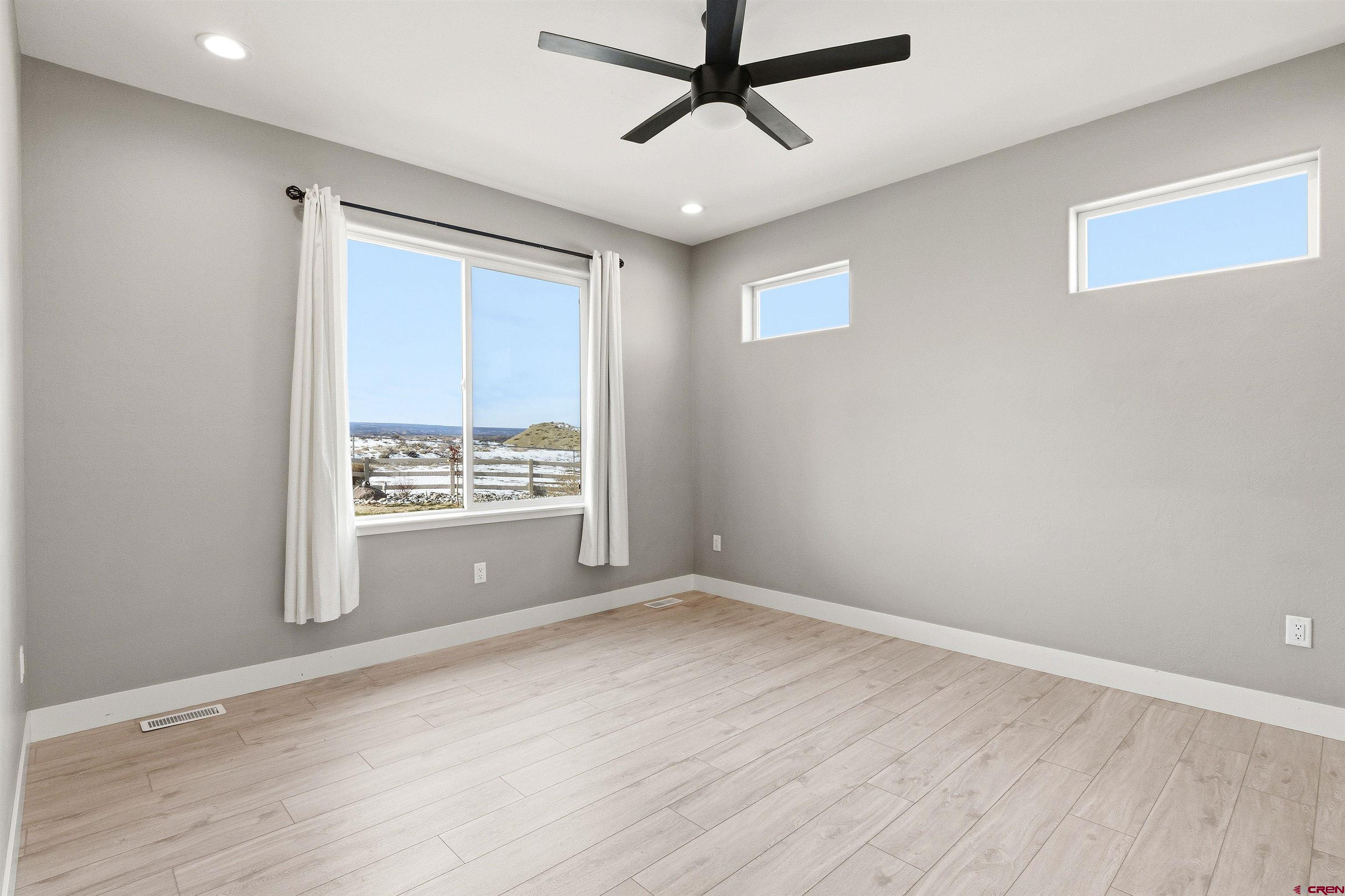 3614 Ridgeline Drive Montrose, CO 81401 - Photo 20 of 45 a view of an empty room with a window and wooden floor
