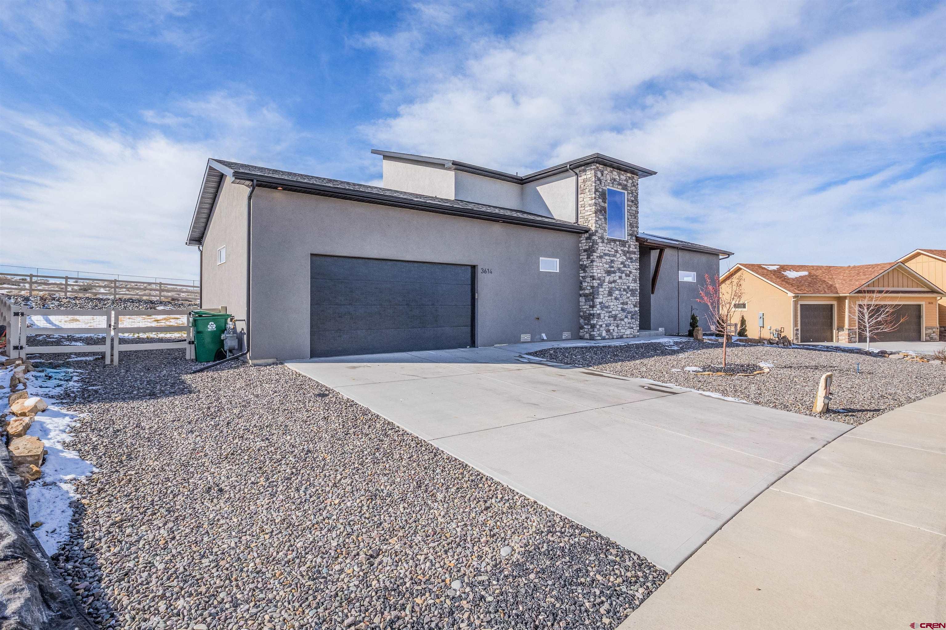3614 Ridgeline Drive Montrose, CO 81401 - Photo 2 of 45 a front view of a house with a yard and garage