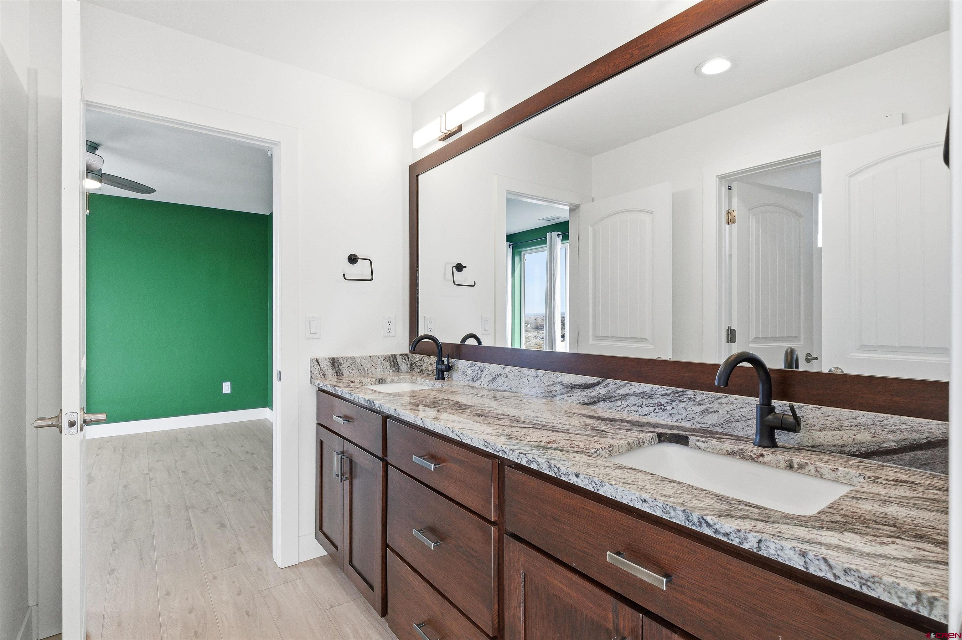 3614 Ridgeline Drive Montrose, CO 81401 - Photo 31 of 45 a bathroom with a granite countertop sink and a mirror