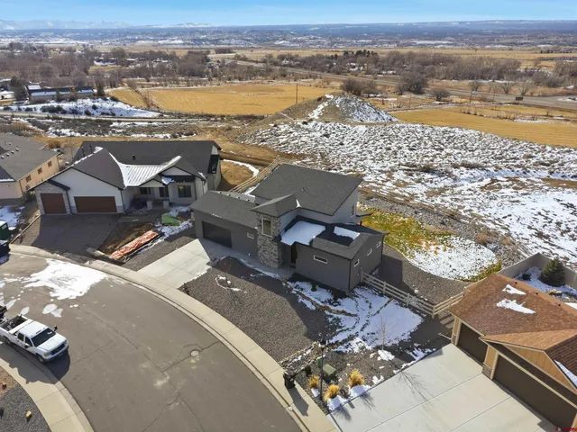 an aerial view of ocean and residential houses with outdoor space