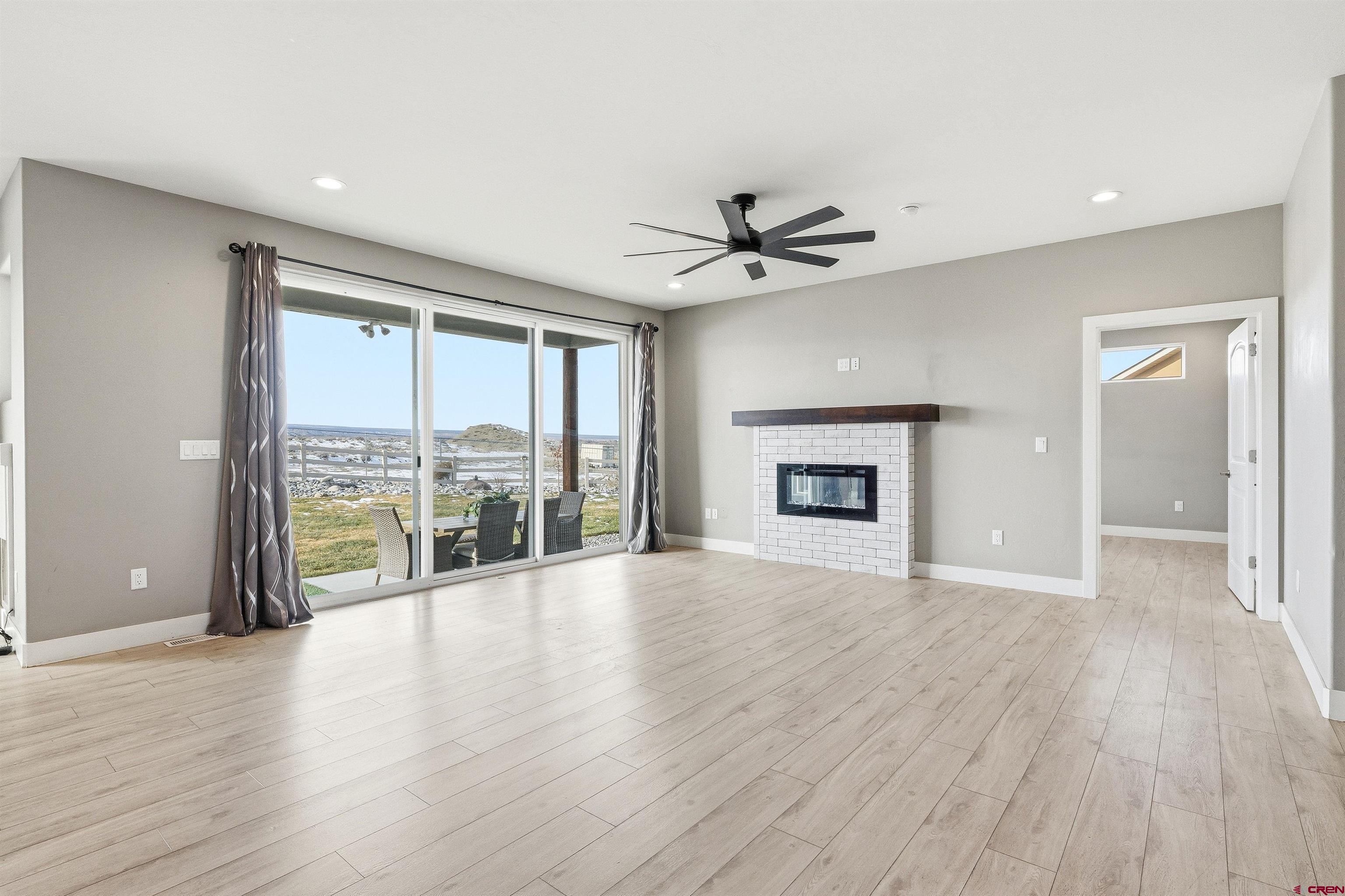 3614 Ridgeline Drive Montrose, CO 81401 - Photo 8 of 45 a view of an empty room with a window and wooden floor