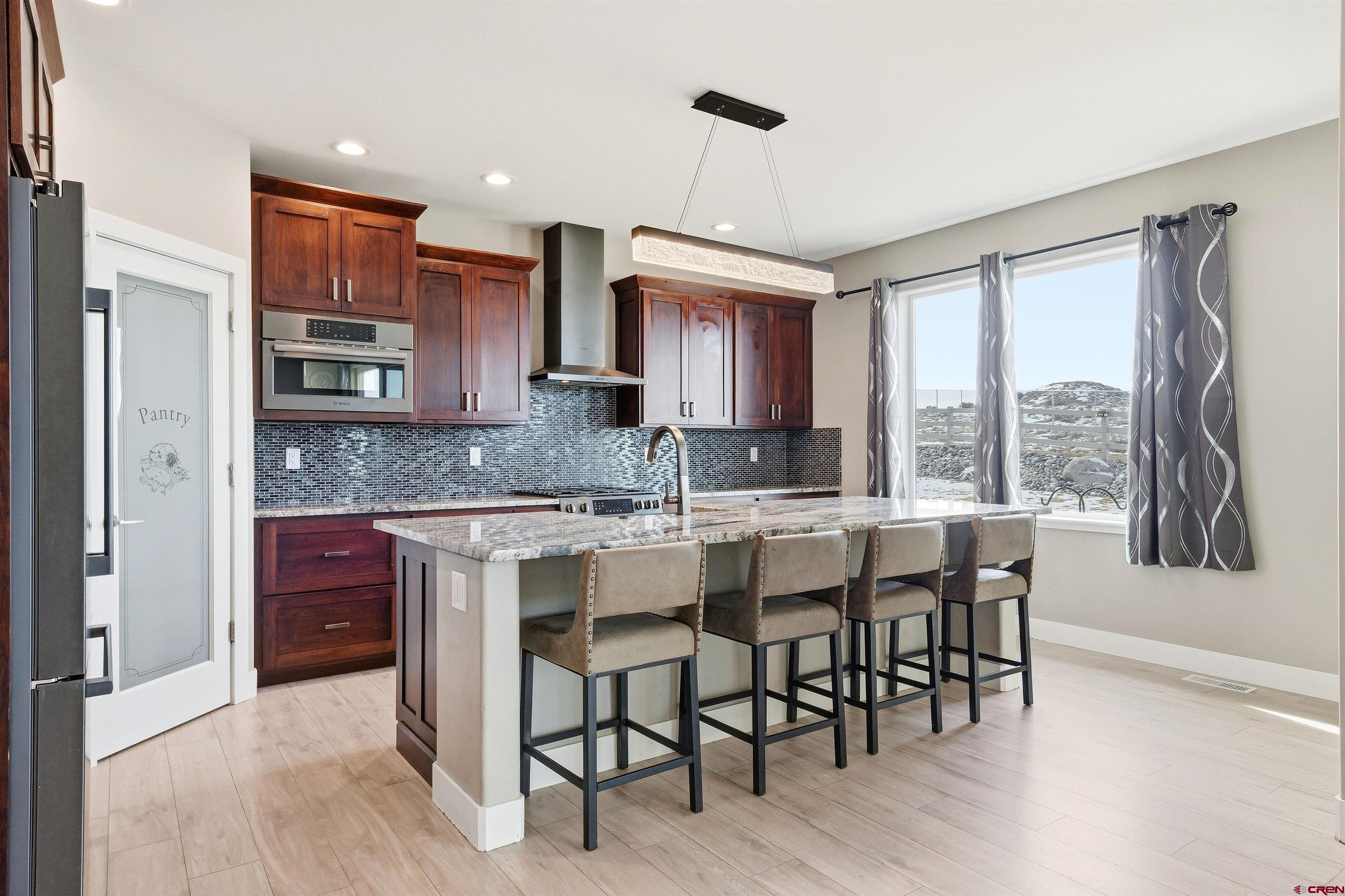 3614 Ridgeline Drive Montrose, CO 81401 - Photo 10 of 45 a kitchen with stainless steel appliances granite countertop wooden cabinets a refrigerator a sink a stove and a microwave