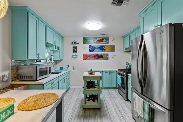 a kitchen with stainless steel appliances granite countertop a refrigerator a stove and a wooden cabinets