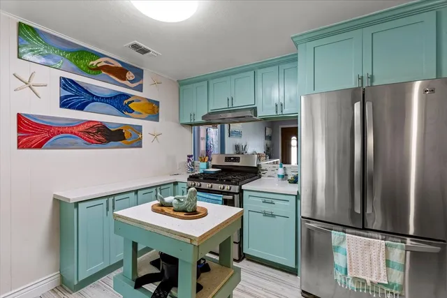a kitchen with stainless steel appliances a stove a refrigerator and a refrigerator
