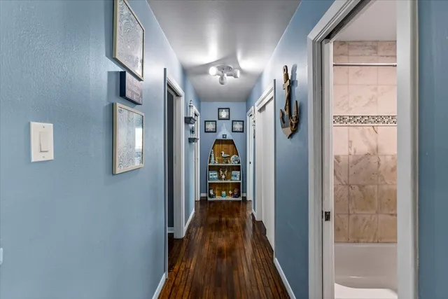 a view of hallway with stairs and wooden floor