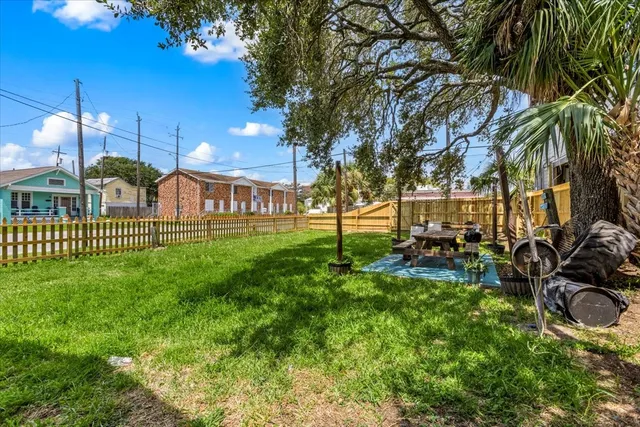 a view of a house with a big yard and large trees