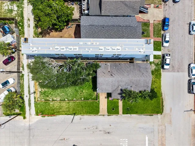 an aerial view of a city with lots of residential buildings ocean and mountain view in back