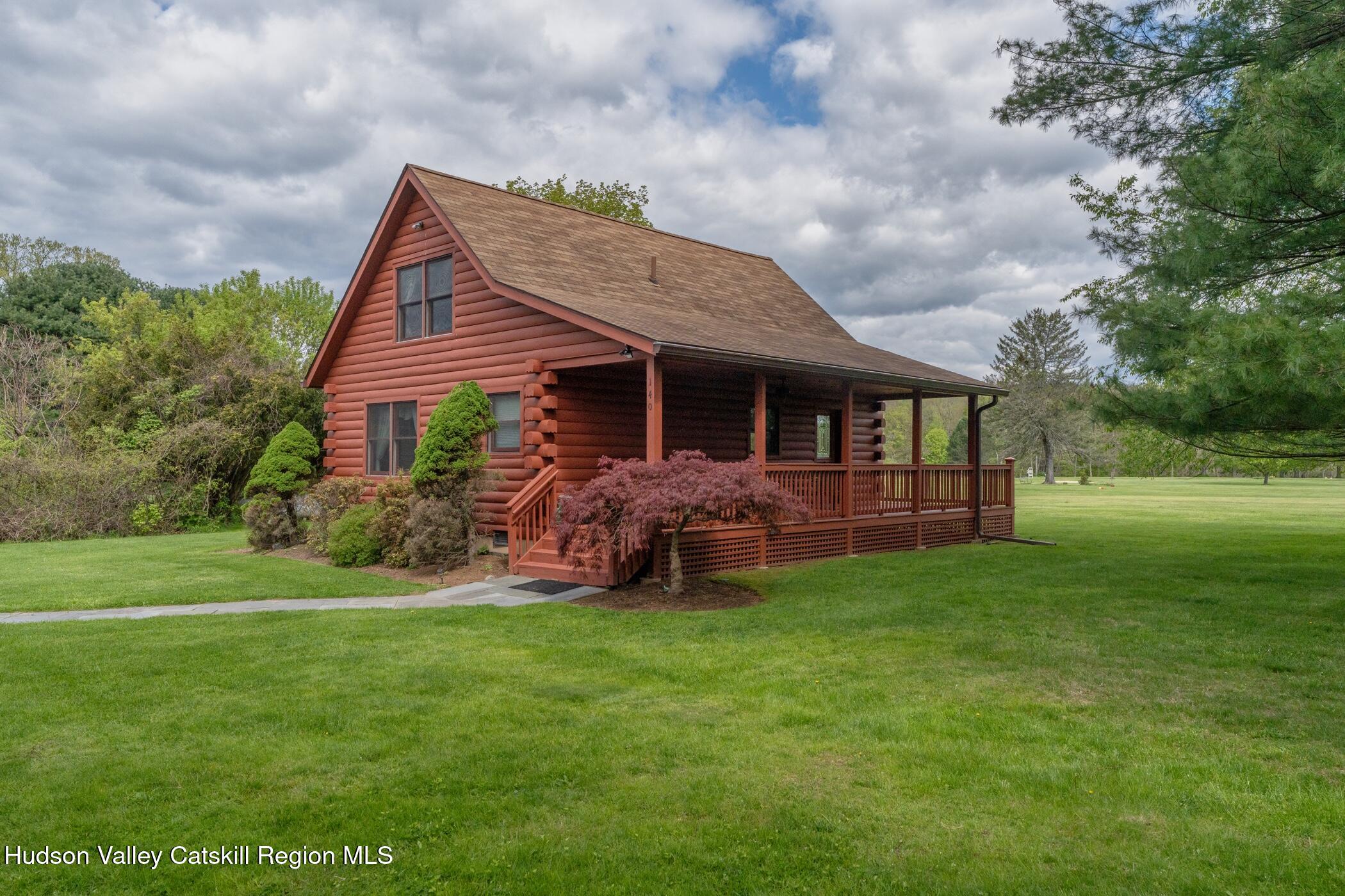 a view of a house with a yard and porch
