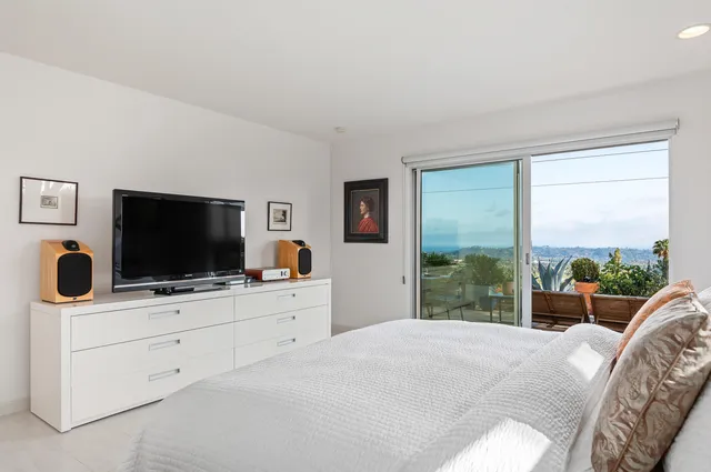 a bedroom with furniture and a flat screen tv