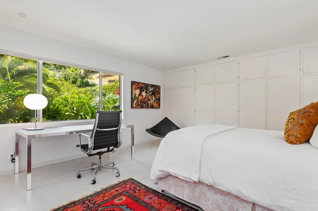 a bedroom with a bed and a large window