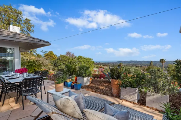 a view of a patio with couches table and chairs and potted plants