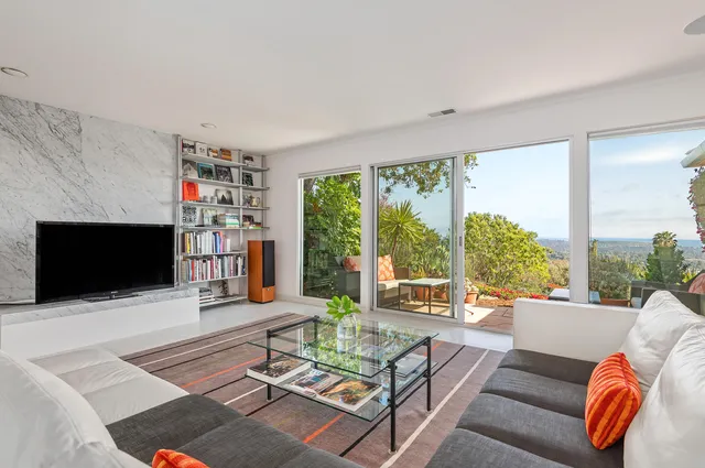 a living room with furniture large window and a flat screen tv