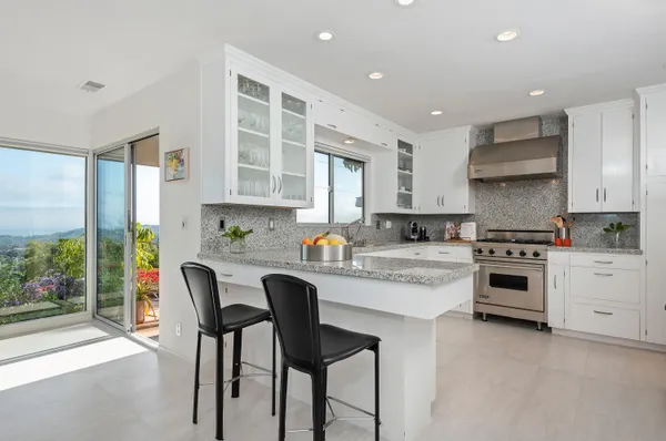 a kitchen with stainless steel appliances granite countertop a stove and white cabinets