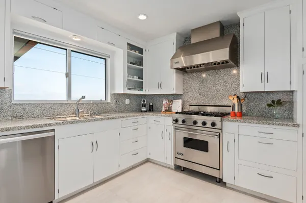a kitchen with white cabinets and white appliances