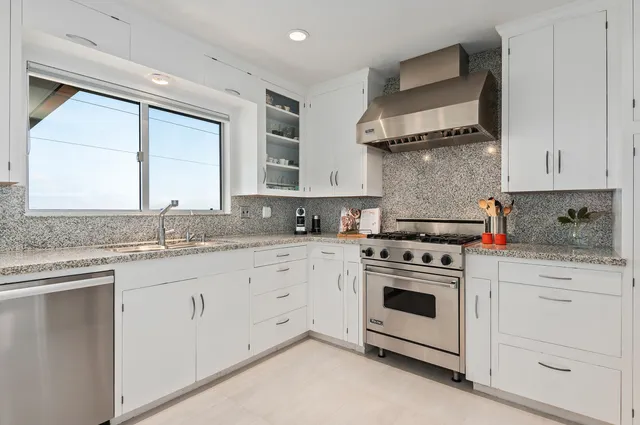 a kitchen with white cabinets and white appliances