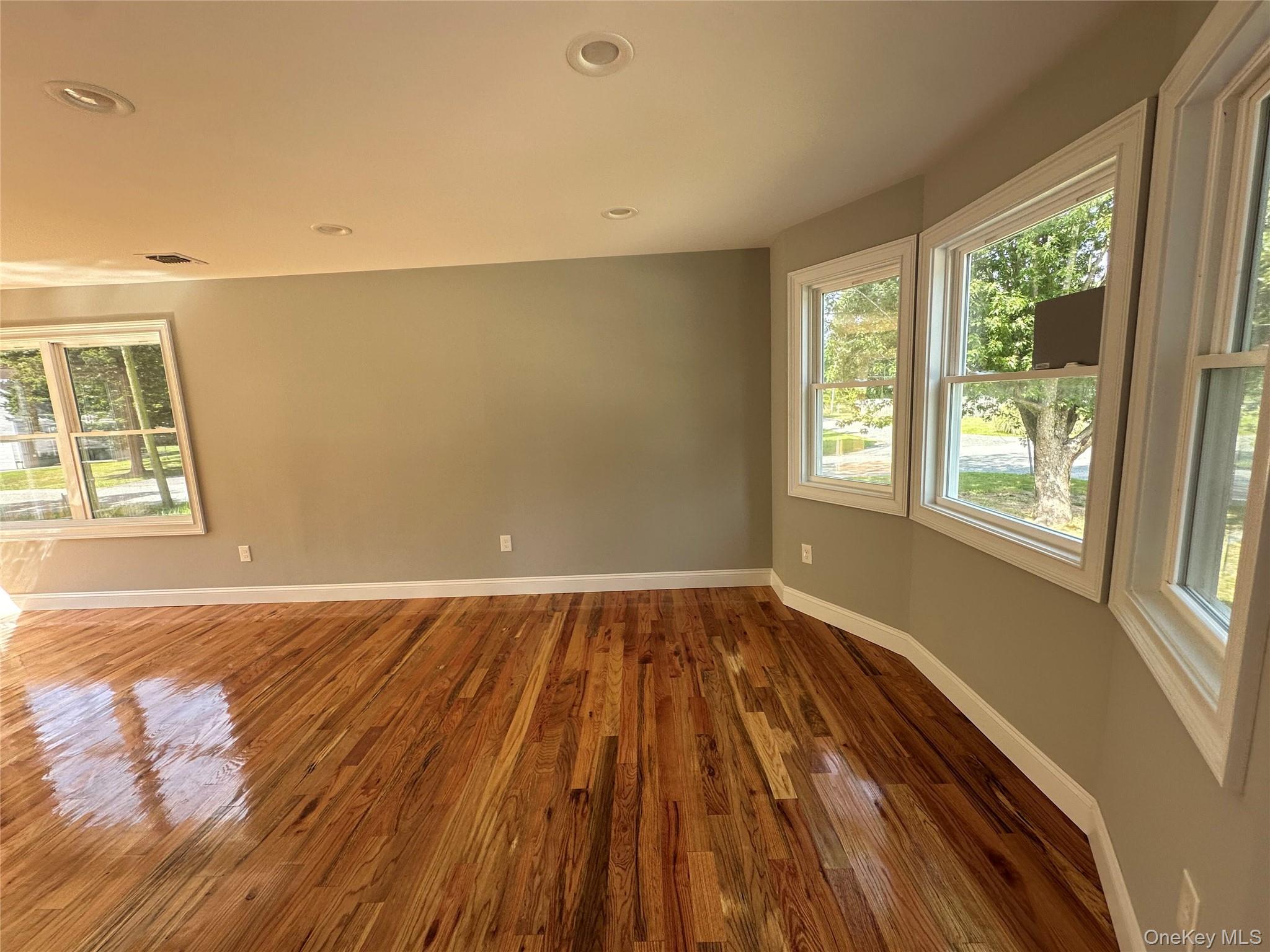 214 Forest Road West Mastic Beach, NY 11951 - Photo 8 of 24 Hardwood flooring throughout featuring recessed lighting and multiple windows