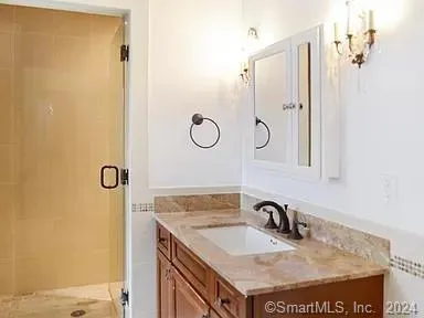 a bathroom with a granite countertop sink and a mirror