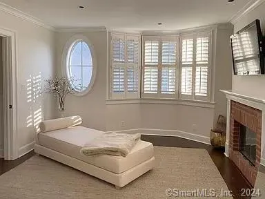 a spacious bedroom with a bed a fireplace and a large window
