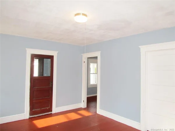 an empty room with closet and mirror