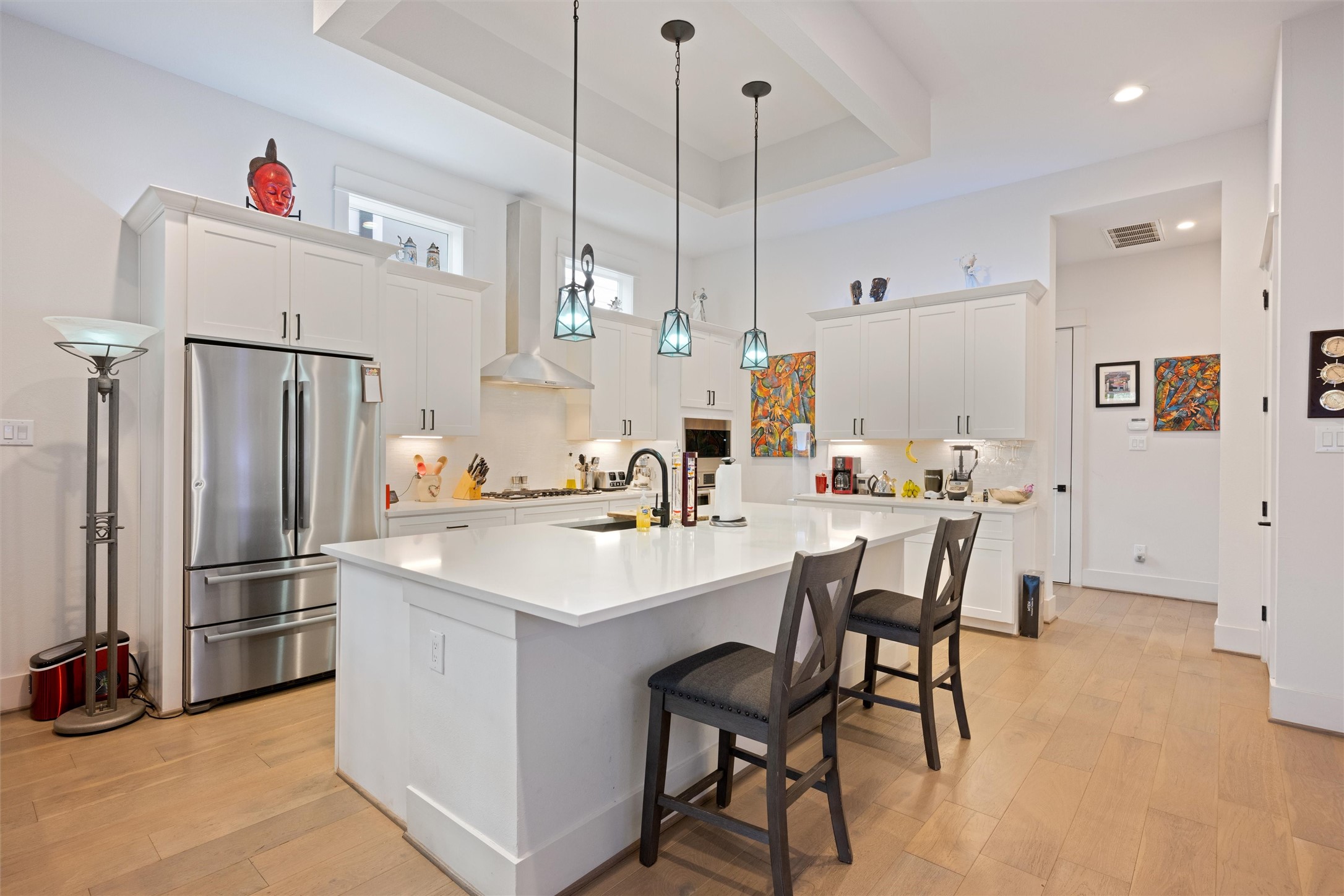 1136 Adele Street Houston, TX 77009 - Photo 3 of 28 a kitchen with stainless steel appliances a refrigerator a sink dishwasher a dining table and chairs with wooden floor