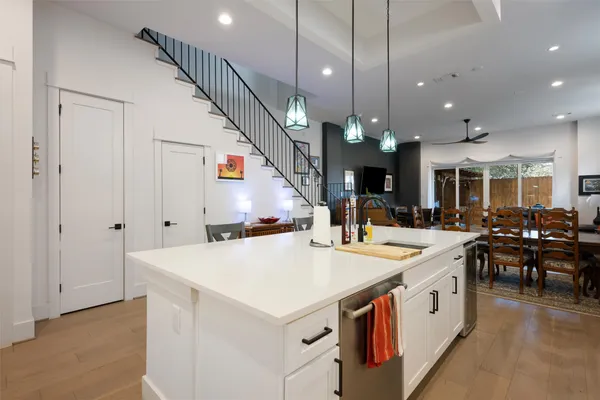 a large white kitchen with a large island oven a stove and a sink