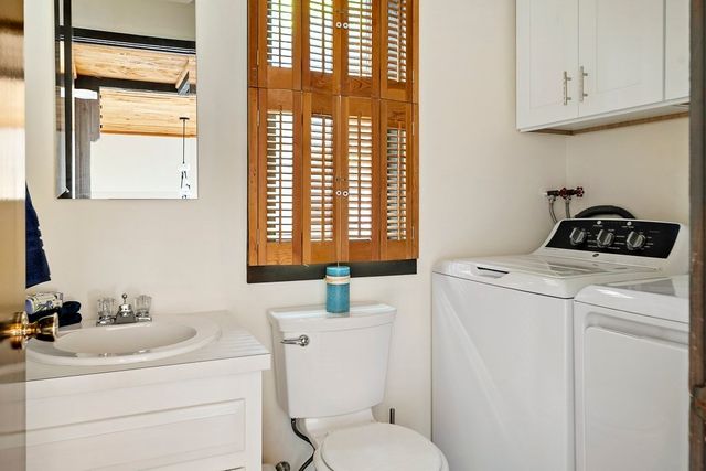 a bathroom with a sink a toilet and a window