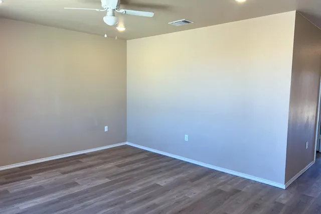 an empty room with wooden floor and closet