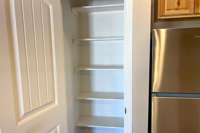 a view of walk in closet with empty racks