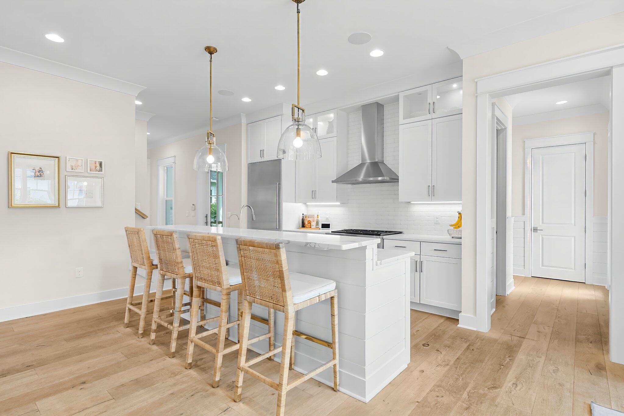 146 Trailhead Drive Inlet Beach, FL 32461 - Photo 11 of 74 a kitchen with stainless steel appliances kitchen island granite countertop a dining table chairs and white cabinets