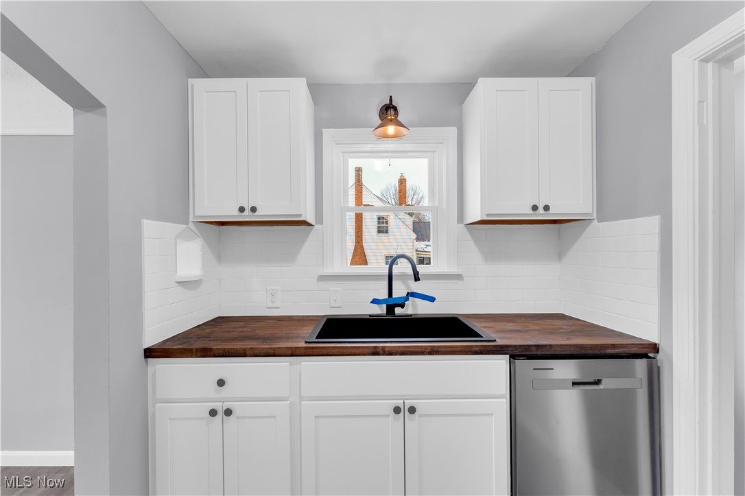 953 Whitby Road Cleveland Heights, OH 44112 - Photo 10 of 27 Kitchen with wood counters, dishwasher, decorative backsplash, and white cabinetry