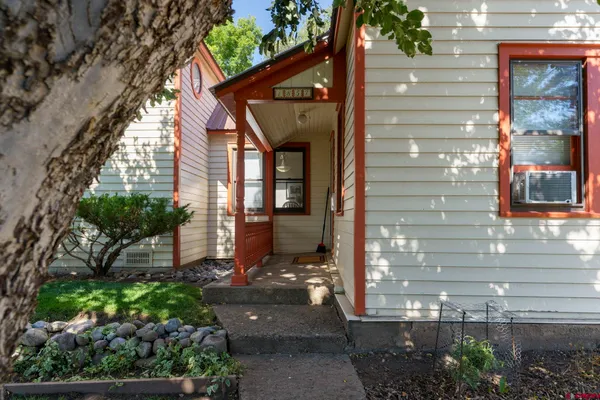 a tree in front of a white house