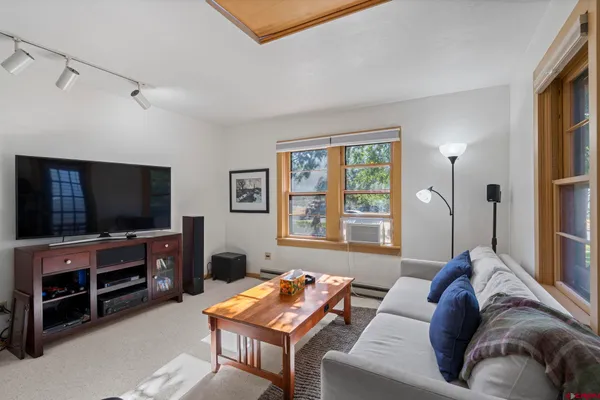 a view of a workspace with furniture and a window