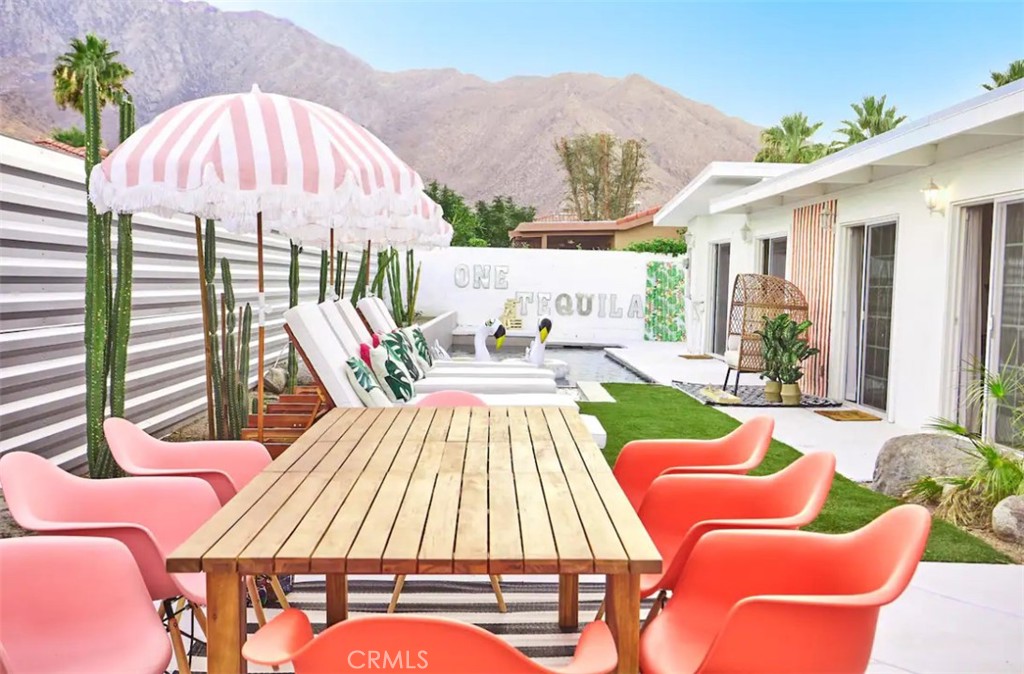 365 Cabrillo Road Palm Springs, CA 92262 - Photo 1 of 1 a view of a patio with couches table and chairs under an umbrella