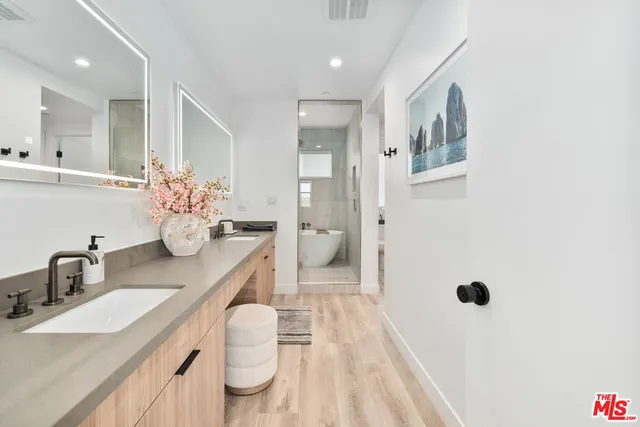 a bathroom with a double vanity sink a mirror and toilet