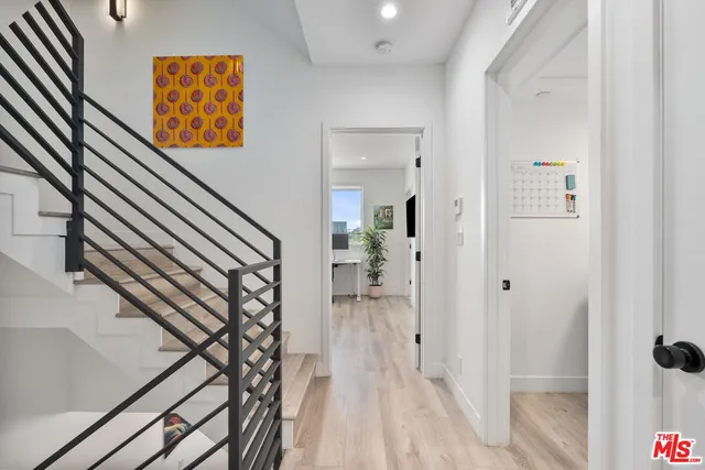 a view of a hallway with wooden floor and staircase