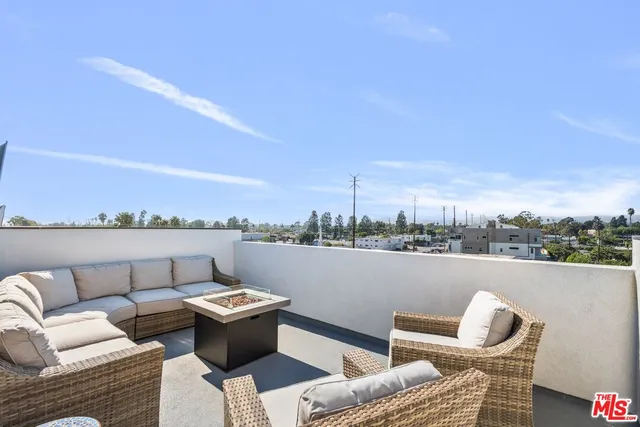 a view of roof deck with couches and city view