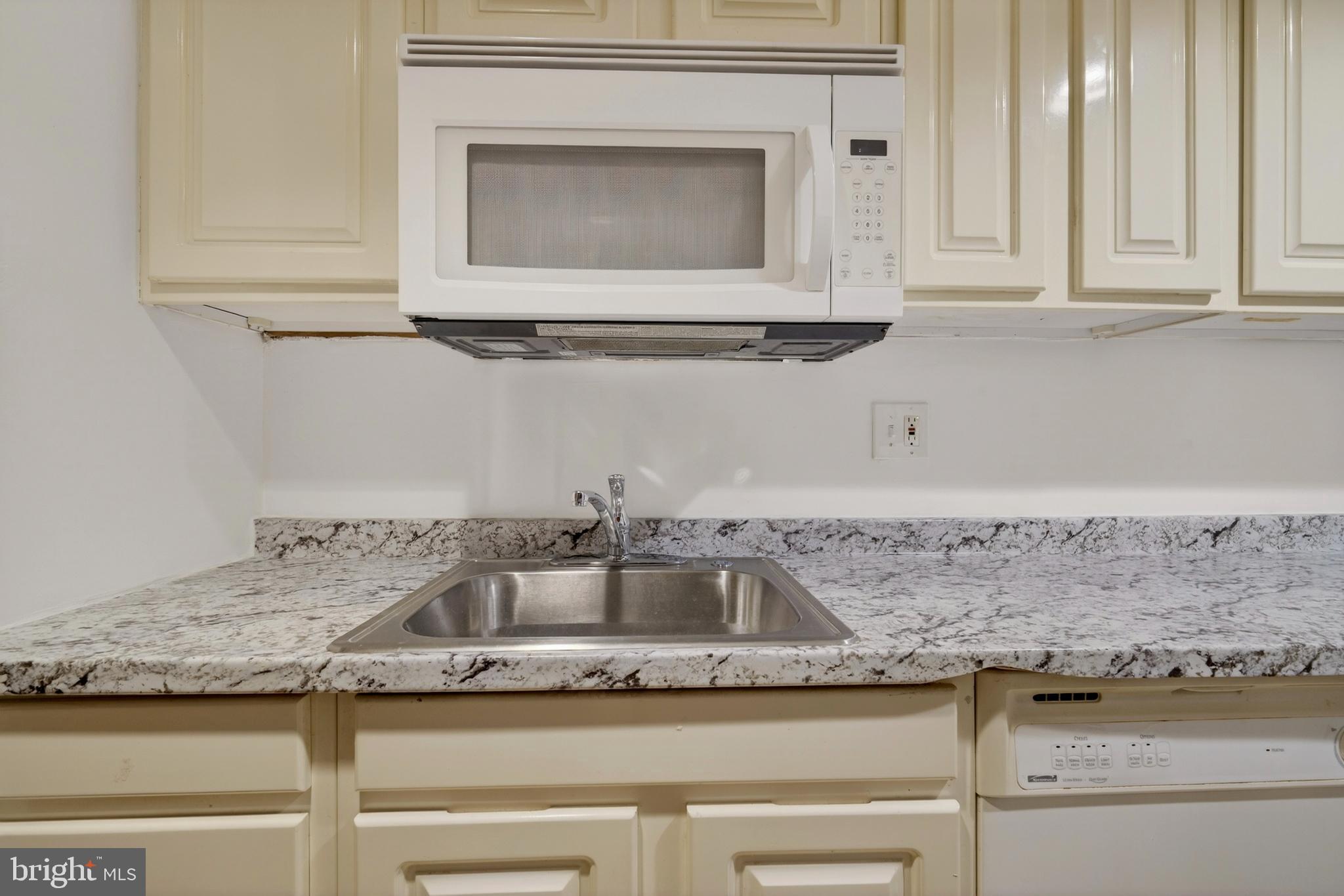 1351 Monroe Street Northwest Washington, DC 20010 - Photo 9 of 23 a kitchen with granite countertop white cabinets and a sink