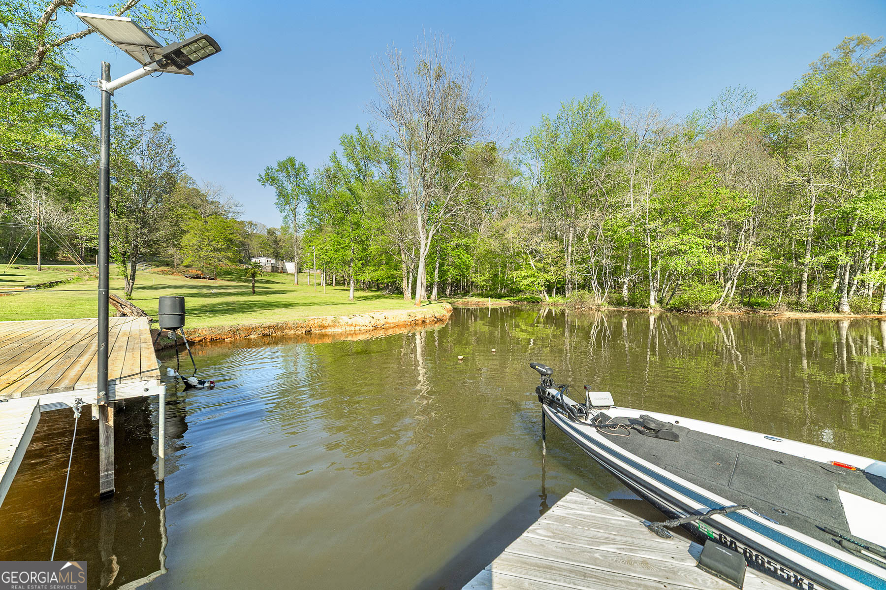 167 Edison Lane Monticello, GA 31064 - Photo 18 of 21 a view of a lake with a wooden deck