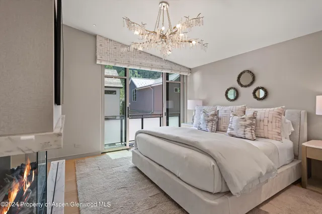 a bedroom with a bed and a chandelier