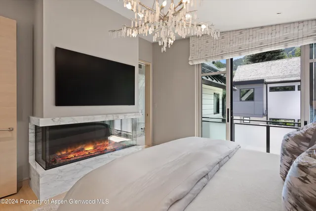 a bedroom with a bed and a flat tv screen on dresser